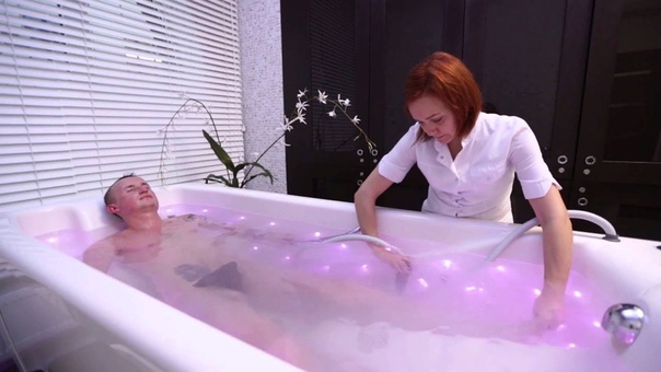 спа процедуры. массирует в ванной. подводный душ. парень с девушкой в ванне. пилинг для тела.